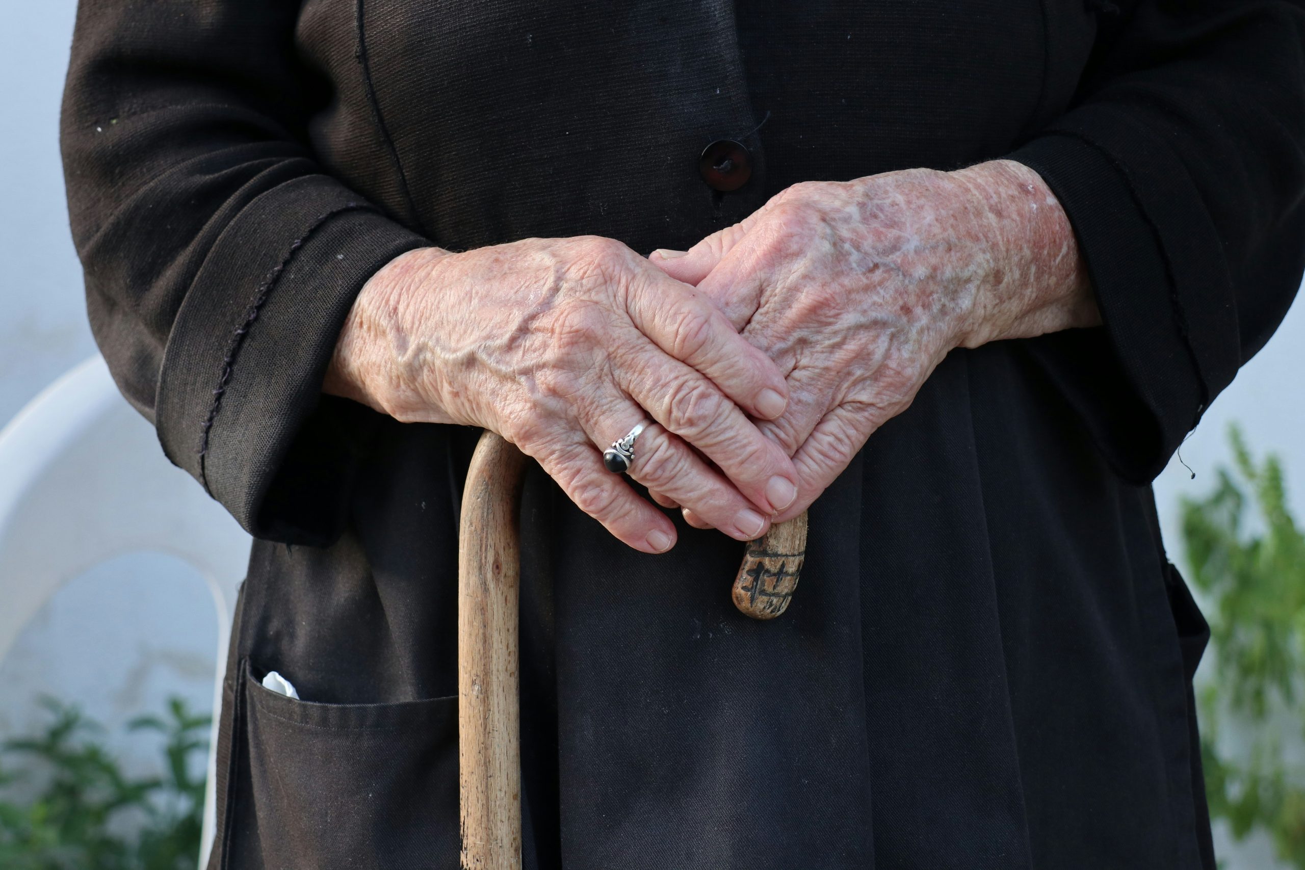 Main âgée avec canne, arthrose visible